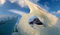 Iceberg with hole and mountain, Iceland