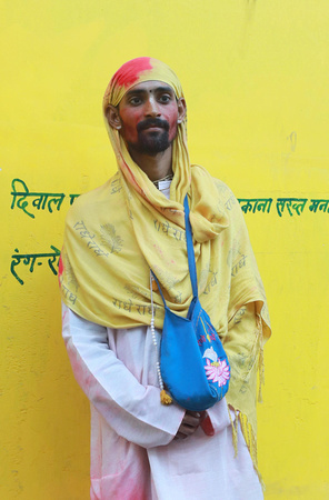 Man with yellow wall at Holi, Vrindavan, India