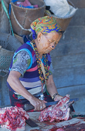 Apatani tribal woman butchering meat, Ziro market, Arunachal Pradesh, India