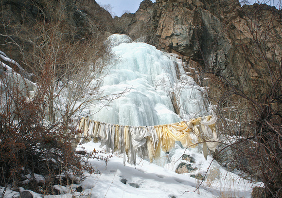 Prayer scarves and frozen waterfall, Hemis National Park, Ladakh, India