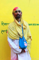 Man with yellow wall at Holi, Vrindavan, India